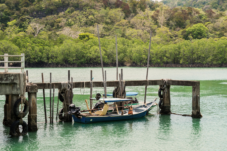 old boat at old harbour on tropical coast in Thailandの写真素材