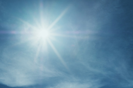 Shiny sun lens flare on blue skyの写真素材