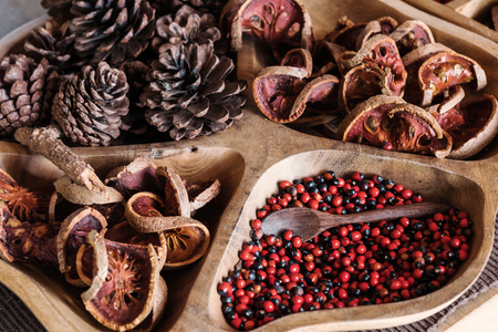 Dried pinecone with bale fruit on wooden tray, selective focus, shallow depth of fieldの写真素材