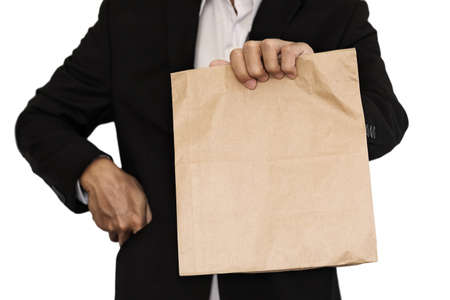 Businessman holding(Sharing,giving) brown paper bag lunch, isolated on white backgroundの写真素材