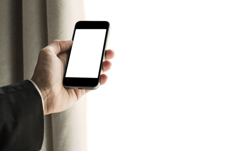 Businessman using mobile phone with curtain opened. and copy spaceの写真素材