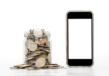 Coins in glass with mobile phone, on white backgroundの写真素材