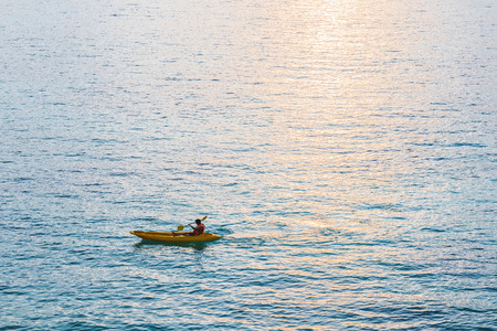 Kayak, a guy kayaking on blue ocean in sunset with sunlight reflection on the seaの写真素材