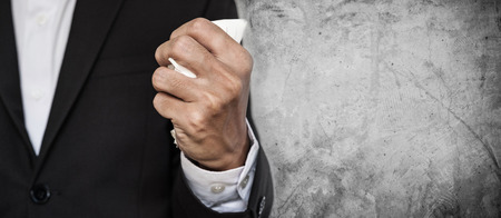 Business employee squeeze crumpled paper in hand, on concrete texture background with copy spaceの写真素材