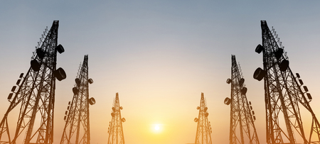 Silhouette, telecommunication towers with TV antennas and satellite dish in sunset, panorama compositionの写真素材