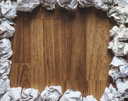 Crumpled paper balls on wooden texture with copy spaceの写真素材