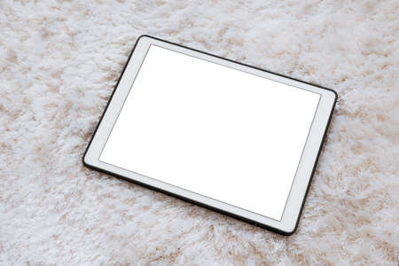 Digital tablet on white wool carpet in living room, with copy space on screen