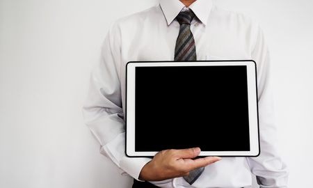 A guy showing digital tablet with blank black screenの写真素材