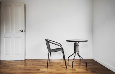 Modern interior space, white wall and laminated wood flooring with chair and tableの写真素材