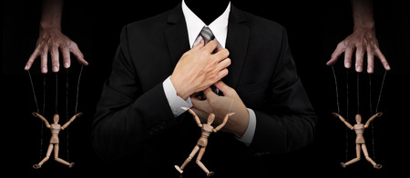 Businessman with wooden figure puppet, concept of business manipulation, panoramic imageの写真素材