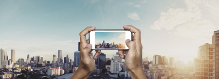 Hand using smartphone taking photo of Bangkok city in sunriseの写真素材