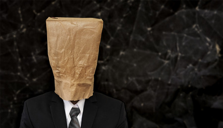 Business people with crumpled brown paper bag on head, with copy space