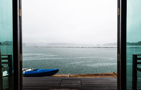 Door opening to beautiful lake view on raft in rainy and cloudy morning