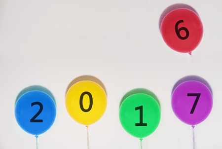 Happy New Years 2017 balloons. year changes balloon from 2016 to 2017 on white wall with copy spaceの写真素材