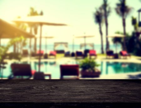 Wooden counter top background, with blurred defocus tropical resort in sunrise, vintage toneの写真素材