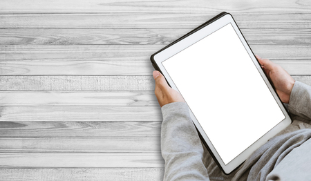 A guy using digital tablet, copy space on screen, on wooden floorの写真素材