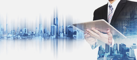 Businessman working on digital tablet with double exposure Bangkok city, concepts of real estate business developmentの写真素材
