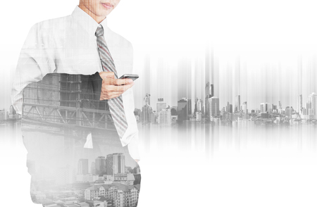 Business employee using smart phone with double exposure cityの写真素材