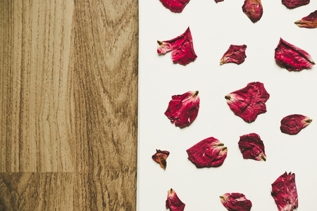 Press dried rose petals, on white paper with wood grain texture, vintage toneの写真素材