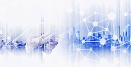 Double exposure businessman working on digital tablet with modern city, network communication technology conceptsの写真素材