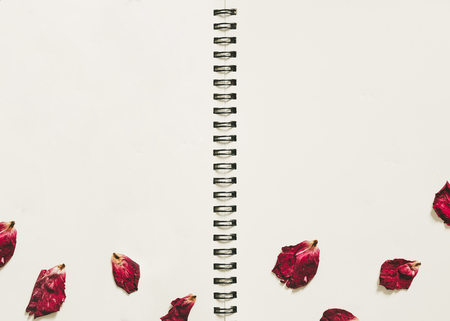 Blank spiral notepad notebook with dry rose petalsの写真素材