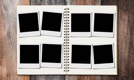 Blank classic film photo frame on photos album, on wooden deskの写真素材