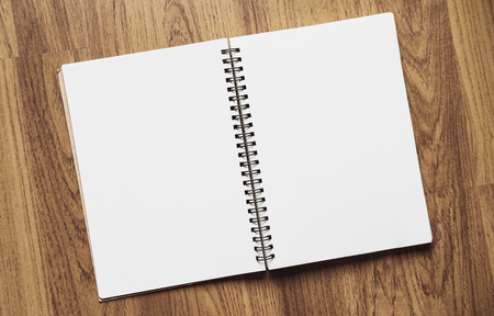 Opened blank binder notebook, with paper on wood textureの写真素材