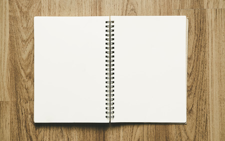 Opened blank binder notebook, with paper on wood textureの写真素材