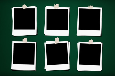 Blank photo frames with tapes, on green board backgroundsの写真素材