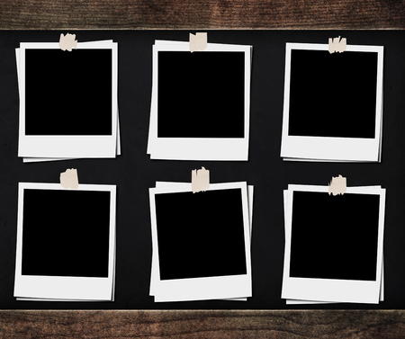 Blank photo frames with tapes, on blackboard backgrounds with wooden frameの写真素材
