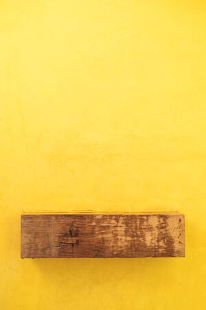 Wooden shelf on yellow wall backgroundの写真素材