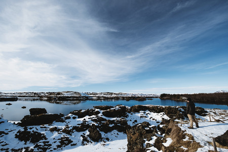 a man standing enjoying amazing beautiful view at winter in Icelandの写真素材