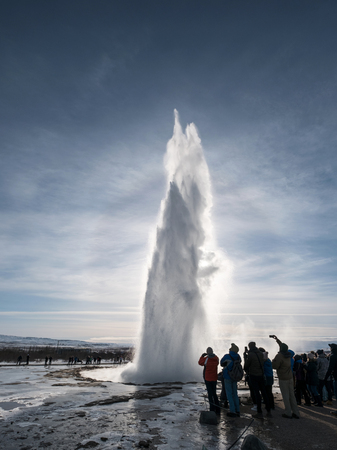 Silhouette, groups of tourist watching natural hot spring geyser erupting in Strokkur, Icelandのeditorial素材