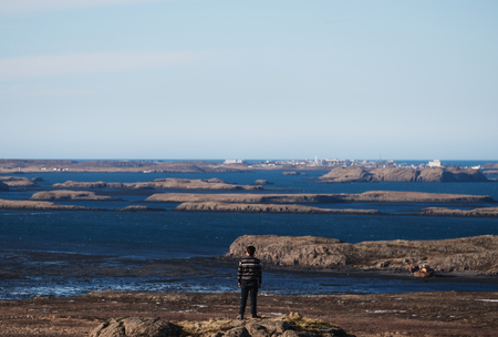 Traveler man standing on rock with serene view of archipelago islandの写真素材