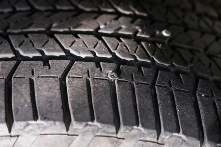 Close-up car wheel with nail in it, selective focusの写真素材