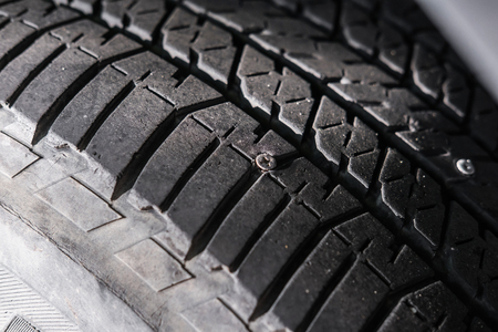 Close-up car wheel with nail in it, selective focusの写真素材