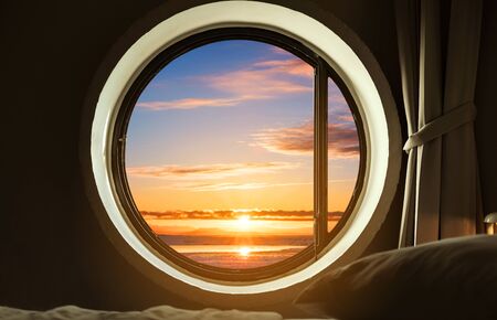 Interior bedroom circle window with beautiful sunrise viewの写真素材