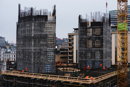 Site construction in the city with workers working in cloudy dayの写真素材