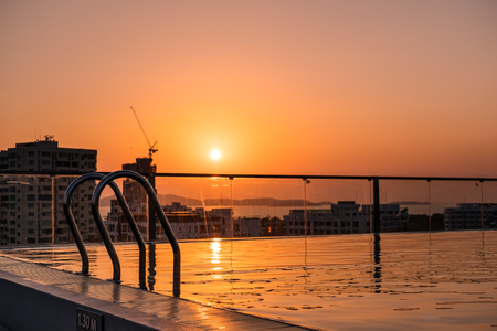 Swimming pool with stair on rooftop in the city in summer sunsetの写真素材