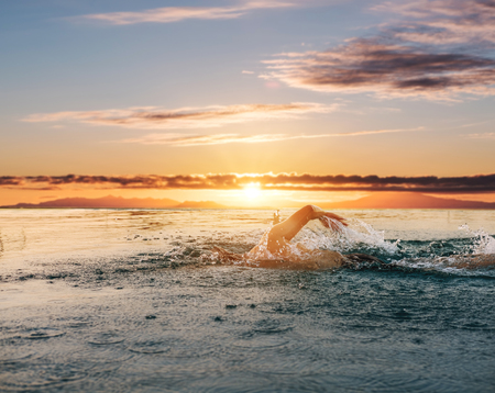 Swimming under sunset sky in summerの写真素材