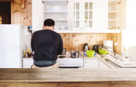 Wooden table top, with blurred defocus a man in kitchen backgroundsの写真素材