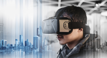 Businessman wearing virtual reality googles, with double exposure modern buildings technologyの写真素材