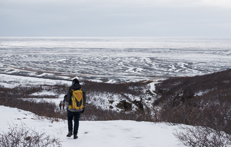 Backpacker walking on snow mountain in winterの写真素材