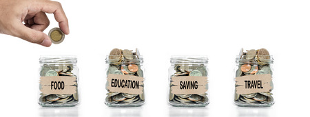 Money collecting, Hand putting coin in glass jar. Saving money for foods,education, future and travelの写真素材