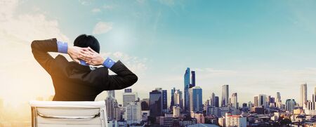 Relax businessman with city in sunrise backgroundの写真素材