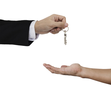 Hands holding and receiving keys, isolated on white backgroundの写真素材