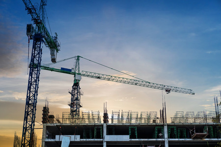 Under construction building with cranes in sunsetの写真素材
