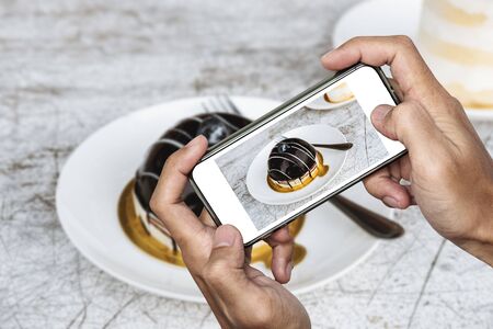 Taking food photo, dessert photography by smart phone, dark sweet chocolate cakeの写真素材