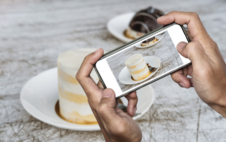 Taking food photo, dessert photography by smart phone, sweet chocolate cake with coconut creme sauceの写真素材