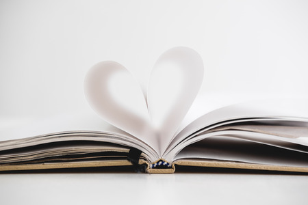 Heart shape on opened notebook page, on white backgroundの写真素材